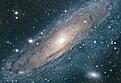 Andrómeda

Andrómeda es la galaxia importante más cercana a la nuestra, la Vía Láctea. Se cree que nuestra galaxia se parece bastante a Andrómeda. En conjunto, ambas galaxias dominan el Grupo Local de galaxias.

La difusa luz que nos llega de Andrómeda tiene su origen en los cientos de miles de millones de estrellas que la forman. Las diferentes estrellas que rodean a Andrómeda en esta fotografía son realmente estrellas de nuestra propia galaxia superpuestas sobre la galaxia de fondo.

A Andrómeda se 